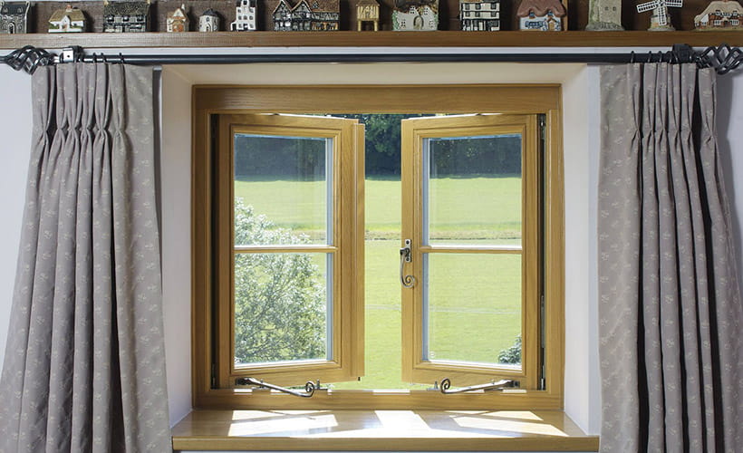 Timber casement windows open to a garden view